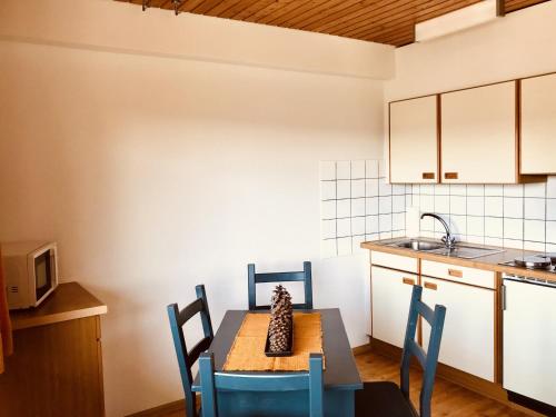 cocina con mesa, sillas y fregadero en Gästehaus Kehrwieder, en Todtnau