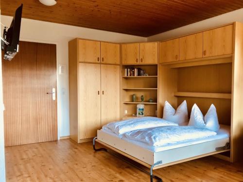 1 dormitorio con 1 cama grande y armarios de madera en Gästehaus Kehrwieder, en Todtnau