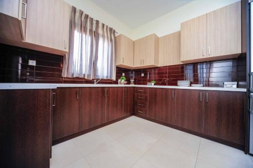 a large kitchen with wooden cabinets and a window at Villa Orsalia in Pigianos Kampos