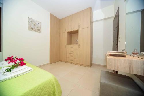 a bedroom with a green bed with a vase of flowers at Villa Orsalia in Pigianos Kampos