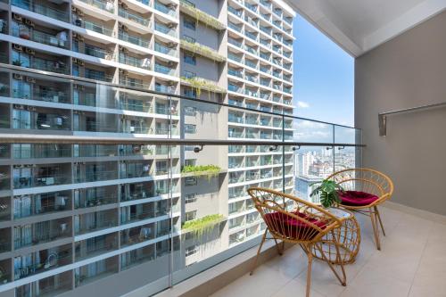 a balcony with two chairs and a large window at The Sóng Luxury Apartment Vung Tau - Tuấn Hoà Homestay in Vung Tau