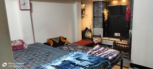 uma sala de estar com uma cama e uma mesa e um quarto em Shree Nath Home Stay em Ujaim