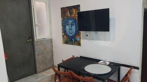 a bathroom with a desk with a sink and a tv at kupenda in Naples