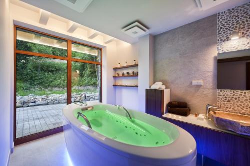 a bathroom with a green tub and a window at Apartamenty przy Hotelu Żywieckim in Przyłęków