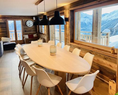 a dining room with a wooden table and chairs at Paradis Perdu SKI IN & QUIET chalet 10 personnes in Les Collons