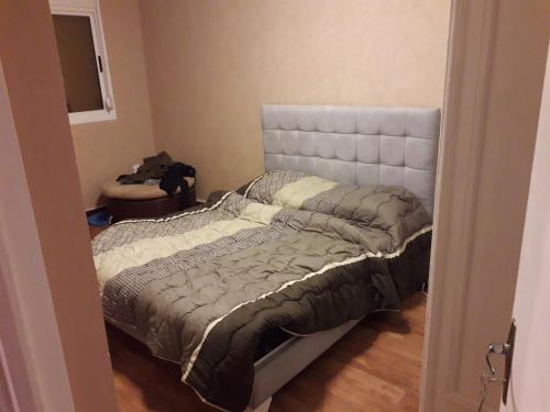 1 dormitorio con 1 cama con cabecero blanco en Très belle F3 près du boulvard, en Tlemcen