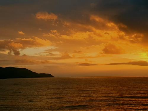 Coastline of Paradise في Paránimfoi: غروب الشمس على المحيط مع السماء