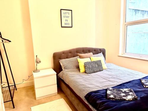 a bed with two pillows on it in a bedroom at Peaceful park side apartment in Hastings