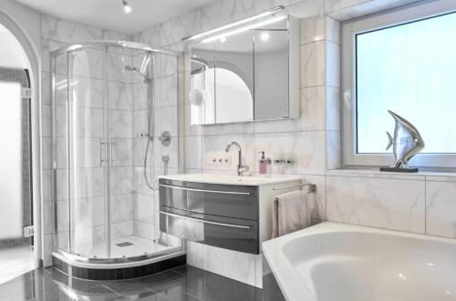 a bathroom with a tub and a sink and a shower at Haus Seeblick in Sipplingen