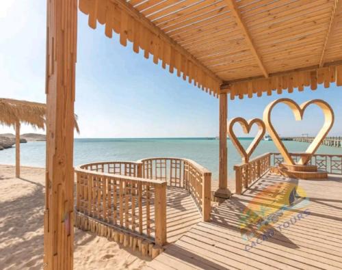 a wooden deck with two hearts on the beach at Dolphin house in Hurghada