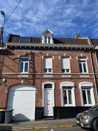 une maison en briques rouges avec un garage blanc dans l'établissement Chambre privée dans maison bourgeoise, à Hem