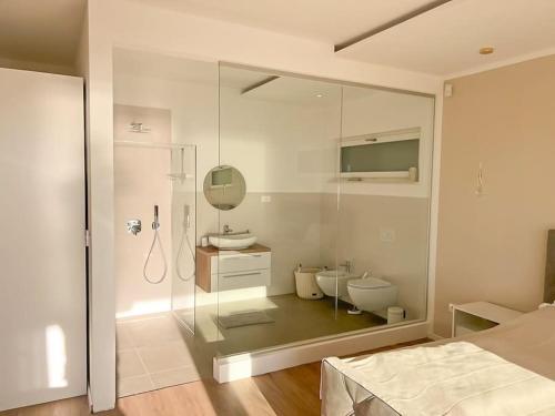 ein Bad mit einer Glasdusche, einem Waschbecken und einem WC in der Unterkunft Villa Maritima-Meerblick-Infinity Pool-Luxus-Relax in Poljane