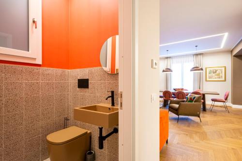 a bathroom with a sink and a toilet and a living room at Casa Alexandra - Luxury & Design in Castellammare del Golfo