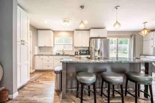 a kitchen with a large island with bar stools at Flagstone Hall! Family Home w Scenic Views in Colorado Springs