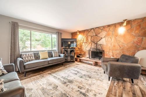 a living room with couches and a stone wall at Flagstone Hall! Family Home w Scenic Views in Colorado Springs