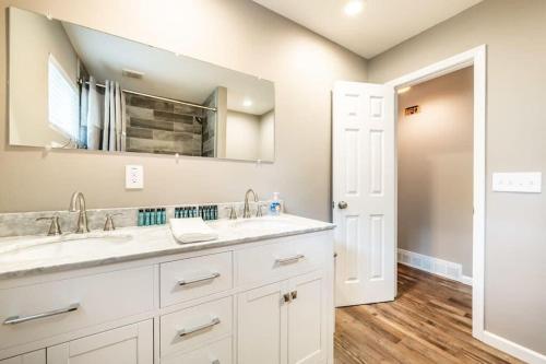 a bathroom with two sinks and a mirror at Flagstone Hall! Family Home w Scenic Views in Colorado Springs