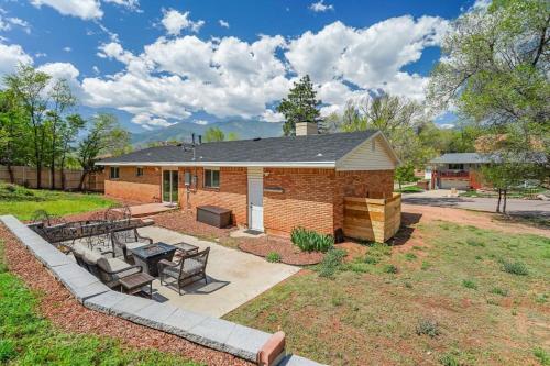 a brick house with a patio with a table and benches at Flagstone Hall! Family Home w Scenic Views in Colorado Springs