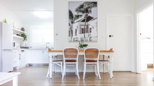 a white kitchen with a table and chairs at Rye's White House in Rye