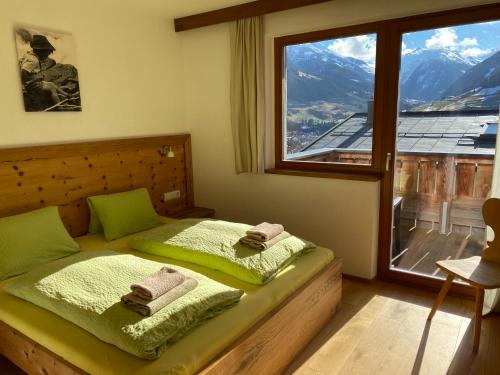 a bedroom with a bed with green sheets and a window at Stadtalm Islitzer in Mittersill