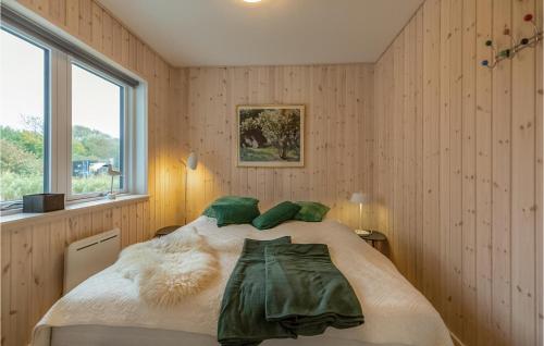 Un dormitorio con una cama con almohadas verdes y una ventana en Cozy Home In Brenderup Fyn With Kitchen, en Vedelshave