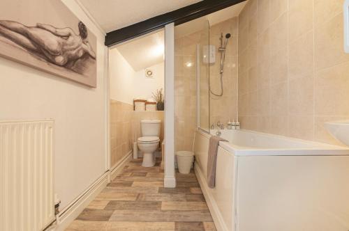 a bathroom with a tub and a toilet and a sink at The Corner Stop~ Dog Friendly Holiday Let in Plymouth in Plymouth