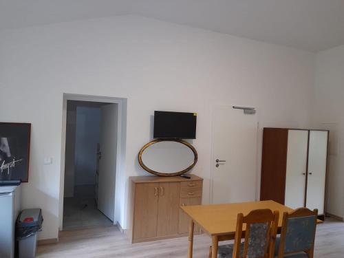 een eetkamer met een tafel en een spiegel bij Schöne Monteurunterkunft in Lohberg mit Grillplatz und Balkon in Lohberg