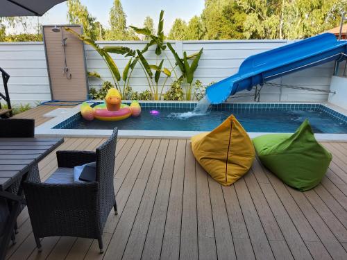 a pool with a raft and two inflatables on a deck at อิมอิม เฮ้าส์ พูลวิลล่า อุดรธานี in Udon Thani