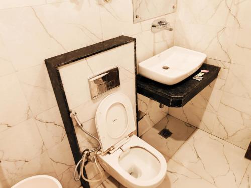 Hotel Tej Plaza Near IGI Airport في نيودلهي: حمام مع مرحاض ومغسلة