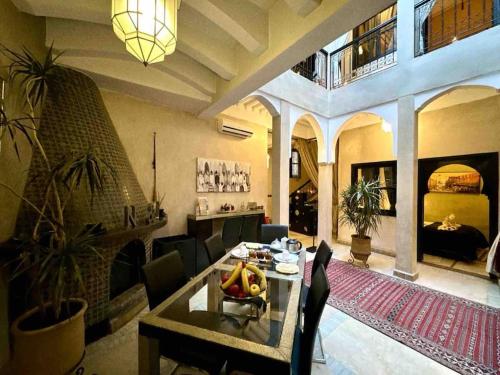 een woonkamer met een eettafel en een woonkamer met bij Riad ART DE VIVRE avec Jacuzzi in Marrakesh