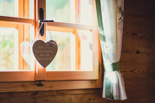 a heart shaped sign hanging from a window at Singerskogel - Ferienhof und Jausnstub`n in Spital am Pyhrn