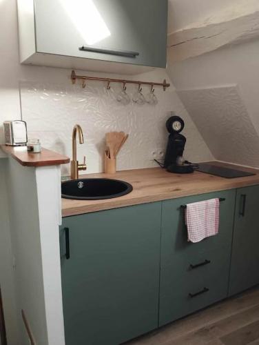 une cuisine avec un évier et un plan de travail dans l'établissement La perle Dieppoise, à Dieppe