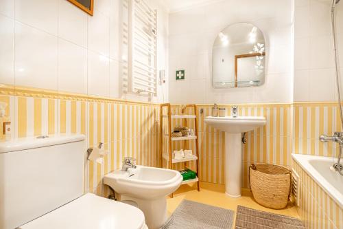 ein Badezimmer mit einem weißen WC und einem Waschbecken in der Unterkunft BeGuest Blue Atlantic View Apartment in Lagoa