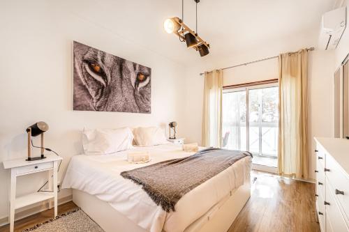 ein weißes Schlafzimmer mit einem großen Bett und einem Fenster in der Unterkunft BeGuest Blue Atlantic View Apartment in Lagoa