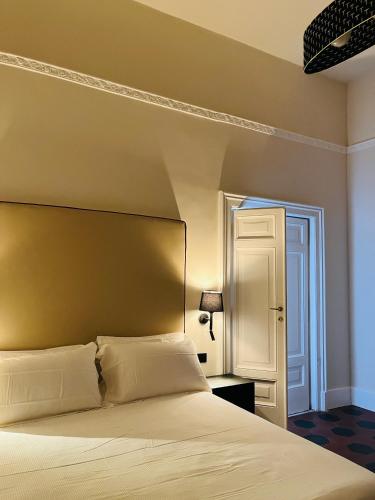 a bedroom with a white bed and a white door at Voglia 'e turnà in Naples