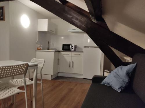 uma sala de estar com uma mesa e uma cozinha em Studio Rémois - WIFI/Netflix em Reims