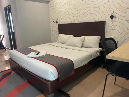 a bedroom with a bed with a phone on it at Stayz Inn Hotels - The Gate Way Of Madras - Near Chennai Central Railway Station in Chennai
