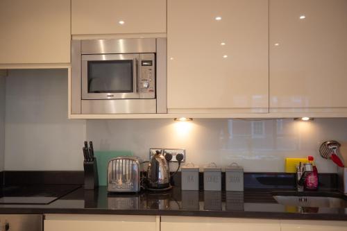 a kitchen with a counter top with a microwave at Two bedroom apartment with 2 bathroom in London