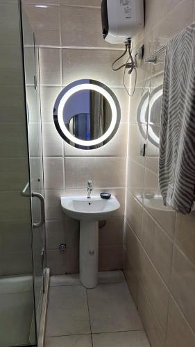 a small bathroom with a sink and a mirror at Delight Bay Shortlet in Lekki
