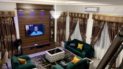 ein Wohnzimmer mit grünen Möbeln und einem Flachbild-TV in der Unterkunft Delight Bay Shortlet in Lekki