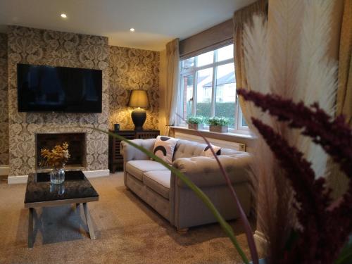 a living room with a couch and a fireplace at Sirius House - sleeps 7, driveway, garden in Crewe