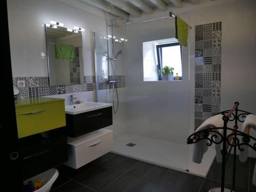 uma casa de banho com uma banheira, um lavatório e um chuveiro em La Maison Forte em Millery