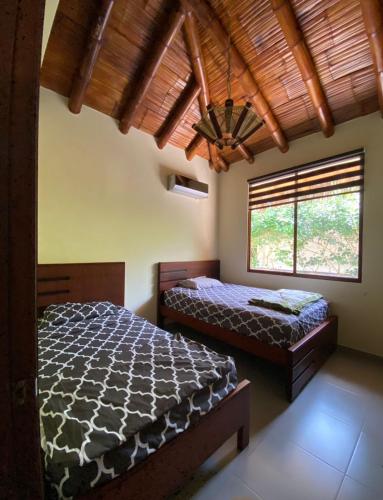 a bedroom with two beds and a large window at Olon de Haciendas Olonche in Olón