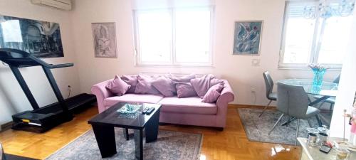 un soggiorno con divano rosa e tavolo di Eli's luxury apartment a Zagabria