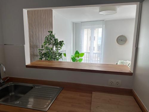 a kitchen with a counter and a sink and a mirror at Apartamento av.Galicia playa in Finisterre