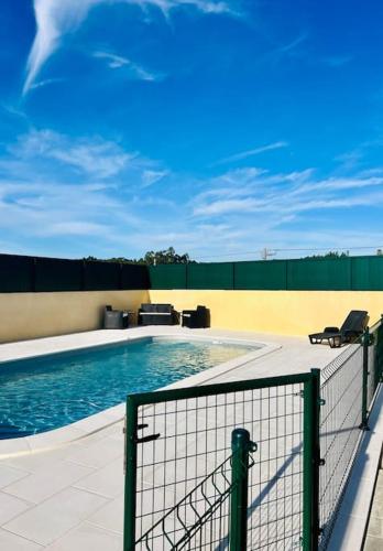 a swimming pool with two chairs and a fence at Antonio's Captain House close to beaches in Atouguia da Baleia