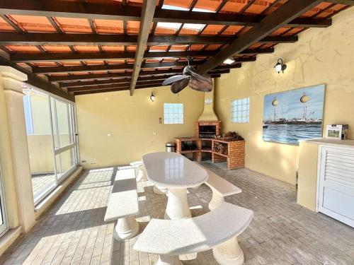 um quarto com uma mesa e bancos num quarto em Antonio's Captain House close to beaches em Atouguia da Baleia
