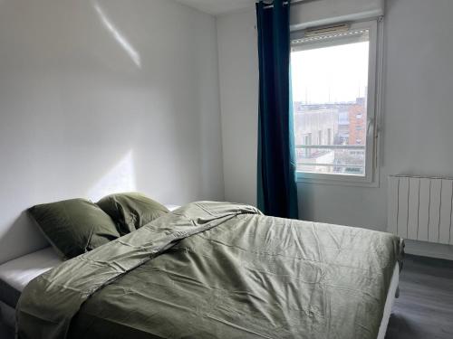 a bed in a room with a window and a bed sidx sidx sidx at Chaleureux nid au cœur du village Olympique in Saint-Denis