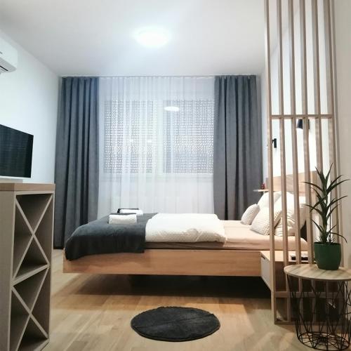 ein Schlafzimmer mit einem großen Bett und einem Fenster in der Unterkunft Apartman 33 in Banja Luka