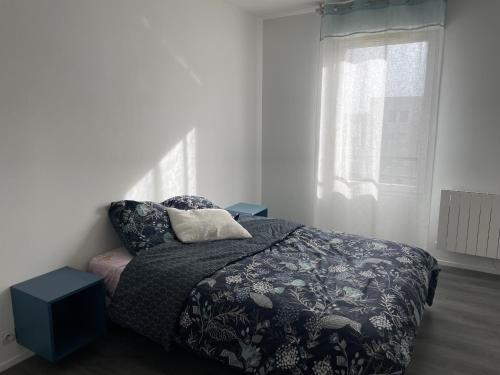 a bedroom with a bed and a pillow and a window at Chaleureux nid au cœur du village Olympique in Saint-Denis