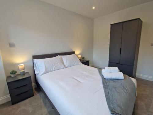 una camera da letto con un grande letto con due asciugamani di Wakefield Getaway - Cosy Apt with Free Parking a Wakefield